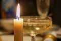 Christmas still life. A glass champagne sparkling wine with bubbles and candle. Royalty Free Stock Photo