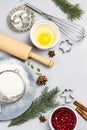 Christmas still life of items for baking cookies. Broken egg in bowl, whisk and sieve, molds, and flour on table Royalty Free Stock Photo