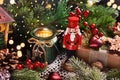 Christmas still life with nutcracker toy and candles on the table in front of Christmas tree