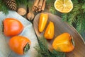 Christmas still life with persimmon and cinnamon on wooden table. Top view. Royalty Free Stock Photo