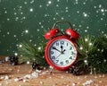 Christmas still life with red alarm clock and pine branches.