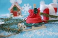 Christmas still life with sleigh with gift bag, gingerbread house, Christmas tree branch and red gift boxes with white ribbons Royalty Free Stock Photo