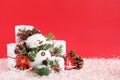 Christmas still life with snowman and gift boxes on a red background with artificial snow. Royalty Free Stock Photo