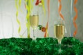 Christmas still life - Two glasses of sparkling wine with blue Xmas balls and tinsel on Christmas tree background Royalty Free Stock Photo