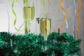 Christmas still life - Two glasses of sparkling wine with golden Xmas decorations on Christmas tree background Royalty Free Stock Photo