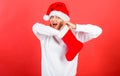 Christmas stocking concept. Girl cheerful face check out gift in christmas sock. Woman in santa hat unpacking christmas Royalty Free Stock Photo