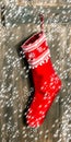 Christmas stocking. Red sock with snowflakes and falling snow Royalty Free Stock Photo