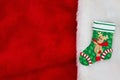 Christmas stocking with a reindeer on red and white plush textured fabric background Royalty Free Stock Photo