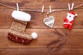 Christmas stocking, santa and heart hanging on brown wooden background, decorative xmas toys on wood table, buying presents shoppi Royalty Free Stock Photo