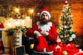 Christmas stockings. Santa winter portrait. Sexy Santa man posing on vintage wooden background. Bearded modern Santa Royalty Free Stock Photo