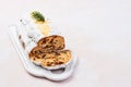 Christmas Stollen cake with icing sugar, marzipan, almonds and raisins on white serving plate