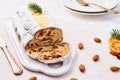 Christmas Stollen cake with icing sugar, marzipan, almonds and raisins on white serving plate Royalty Free Stock Photo