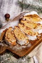 Christmas stollen on a cutting board. Wooden white table background. Traditional Christmas pastry with marzipan, nuts, raisins Royalty Free Stock Photo