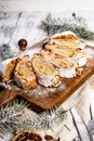 Christmas stollen on a cutting board. Wooden white table background. Traditional Christmas pastry with marzipan, nuts, raisins Royalty Free Stock Photo