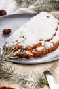 Christmas stollen on a gray plate. Wooden white table background. Traditional Christmas pastry with marzipan, nuts and raisins. Royalty Free Stock Photo
