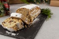 Christmas stollen with a mixture of dried fruits, nuts and powdered sugar on a board.