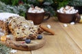 Christmas stollen with a mixture of dried fruits, nuts and powdered sugar on a board.
