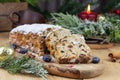 Christmas stollen with a mixture of dried fruits, nuts and powdered sugar on a board.