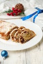 Christmas stollen on plate on white wooden table close up