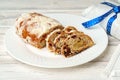 Christmas stollen on plate on white wooden table close up