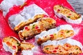 Christmas Stollen, traditional german christmas cake with dried fruits, nuts, spices and icing sugar decorated with red and gold r Royalty Free Stock Photo