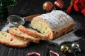 Christmas Stollen. Traditional Sweet Fruit Loaf with Icing Sugar. Xmas Holiday Table Setting, Decorated with Mini Tree Christmast