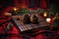 christmas storybook on tartan cloth with pine cones near