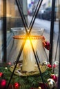 Christmas street decoration. Big white burning candle in jar candleholder inside big vintage lantern decorated with fresh fir ball Royalty Free Stock Photo