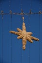 Christmas street decoration showflake shape on the wire againt the blue sky