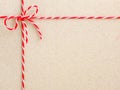 Red twine string tied in a bow on paper backdrop. Royalty Free Stock Photo