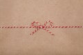 Christmas string or twine tied in a bow on kraft paper background Royalty Free Stock Photo