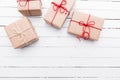 Christmas style rustic brown paper package tied up with strings. White wood background. Royalty Free Stock Photo