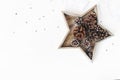 Christmas styled table composition. Pine and larch cones in star shaped wooden tray, silver confetti and silk ribbon