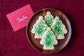 Christmas sugar cookies for Santa on a wood plate, note to Santa, red fabric background