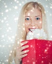 Christmas surprise and glitter snow background, happy blonde model with gift boxes in winter season for shopping sale