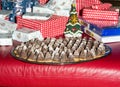 Christmas sweets in foreground. Christmas presents and a decoration in blurry background Royalty Free Stock Photo