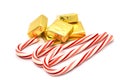 Christmas sweets: red and white striped candy canes and chocolates in a golden wrapper