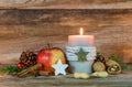 Christmas decoration with candle light, star cookie, red apple, nuts and aromatic spices Royalty Free Stock Photo