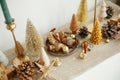 Christmas table decor. Stylish christmas golden trees, runner with gold stars, shiny baubles and candles on table. Modern gold Royalty Free Stock Photo