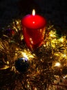 Christmas table decoration with red candle, blue balls, tinsel, gold Royalty Free Stock Photo