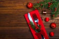 Christmas table: knife and fork, napkin and Christmas tree branch on a wooden table top view with copy space.