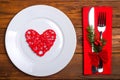 Christmas table: knife and fork, plate, napkin and Christmas tree branch on a wooden table top view with copy space. Royalty Free Stock Photo