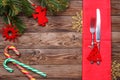 Christmas table place setting with fork and knife, decorated christmas toy - red fir-tree, christmas pine branches and two Royalty Free Stock Photo