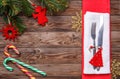 Christmas table place setting with fork and knife, decorated christmas toy - red fir-tree, christmas pine branches and two Royalty Free Stock Photo