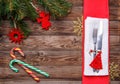 Christmas table place setting with fork and knife, decorated christmas toy - red fir-tree, christmas pine branches and Royalty Free Stock Photo
