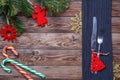 Christmas table place setting with fork and knife, decorated christmas toy - red fir-tree, christmas pine branches and Royalty Free Stock Photo