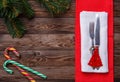 Christmas table place setting with fork and knife, decorated christmas toy - red fir-tree, two lollipop cane and Royalty Free Stock Photo