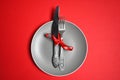 Christmas table with a plate, fork, knife. top view, copy space. against a red background Royalty Free Stock Photo