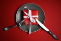 Christmas table with a plate, fork, knife. top view, copy space. against a red background Royalty Free Stock Photo