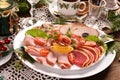 Christmas table with a platter of sliced ham and cured meat Royalty Free Stock Photo